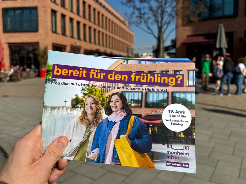 Eine Hand hält das Couponheft fest.